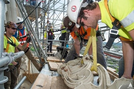 workers lifting object with overhead crane